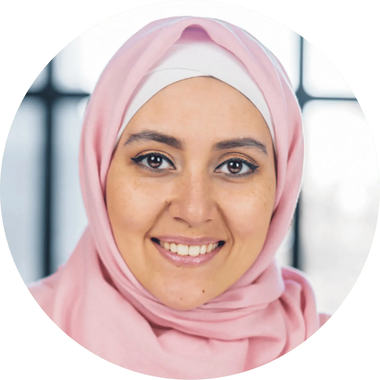 A woman in a headscarf smiling at the camera.